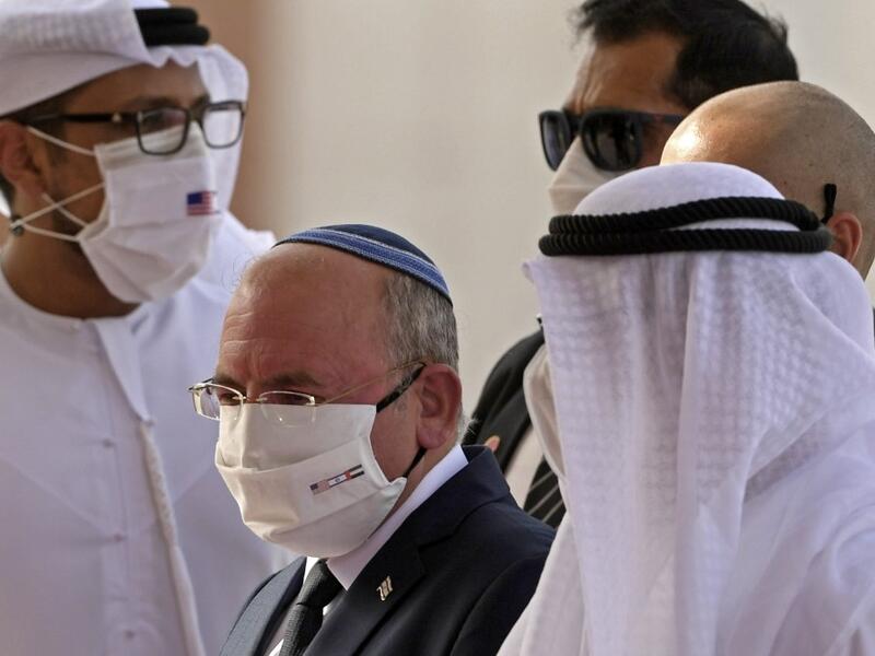 The Head of Israel's National Security Council, Meir Ben-Shabbat (C), wearing a facemask to avoid the spread of the Covid-19 coronavirus, walks alongside an Emirati official at Abu Dhabi airport following the arrival of the first-ever commercial flight from Israel to the UAE, on August 31, 2020. KARIM SAHIB / AFP