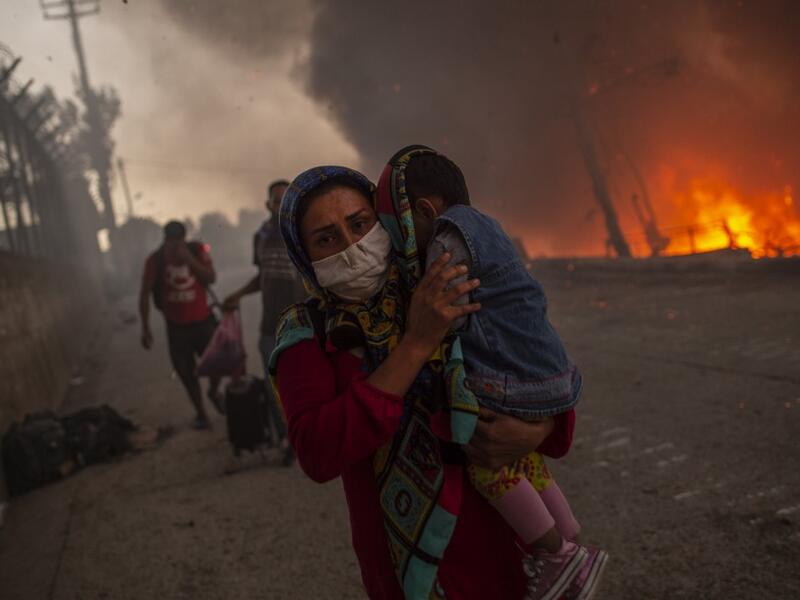 A large fire broke out at Moria, Europe's largest refugee camp on Lesbos in Greece, forcing thousands including many families with children out into the streets with nowhere to sleep.   A second fire aggravated the crisis on the island of Lesbos, where authorities have declared a state of emergency.  The first blaze, which began hours after 35 people tested positive for coronavirus at the Moria camp, sent thousands fleeing for safety into surrounding olive groves.