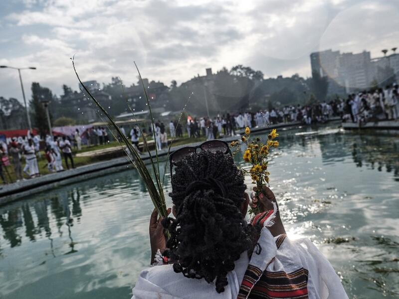 A woman sprays herself water as part of the celebration of “Irreechaa”, the Oromo people thanksgiving holiday, in Addis Ababa, Ethiopia, on October 3, 2020. Members of Ethiopia's largest ethnic group gathered under heavy security in Addis Ababa for a scaled-back version of their annual thanksgiving festival against a backdrop of unrest and political division. EDUARDO SOTERAS / AFP