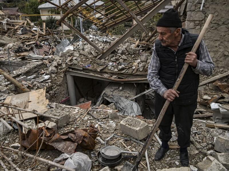 Retired police officer Genadiy Avanesyan, 73, searches for belongings in the remains of his house, which is said was destroyed by Azeri shelling, in the city of Stepanakert on October 10, 2020. Amenia and Azerbaijan traded accusations of new attacks on October 10 in breach of a ceasefire deal to halt nearly two weeks of fierce fighting over the disputed Nagorno-Karabakh region. ARIS MESSINIS / AFP