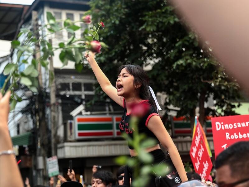 A pro-democracy protester holds up flowers while shouting slogans during an anti-government rally in Bangkok on October 14, 2020. Jack TAYLOR / AFP
