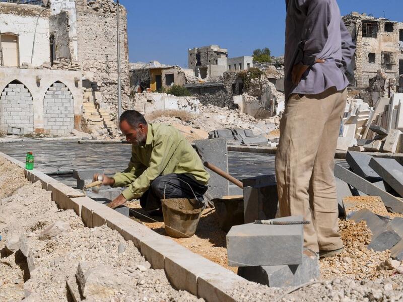 Syrian workers take part in the reconstruction of the Hatab Square in the Jdaideh neighbourhood in Aleppo's Old City on October 17, 2020. AFP