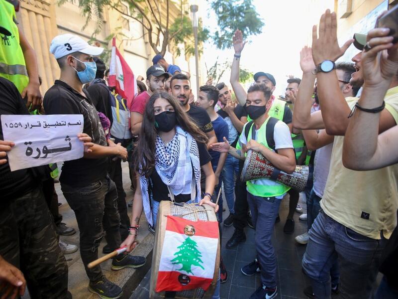 Lebanese demonstrators play music during a demonstration, marking the first anniversary of a non-sectarian protest movement, in the capital Beirut's downtown area on October 17, 2020. Anwar AMRO / AFP