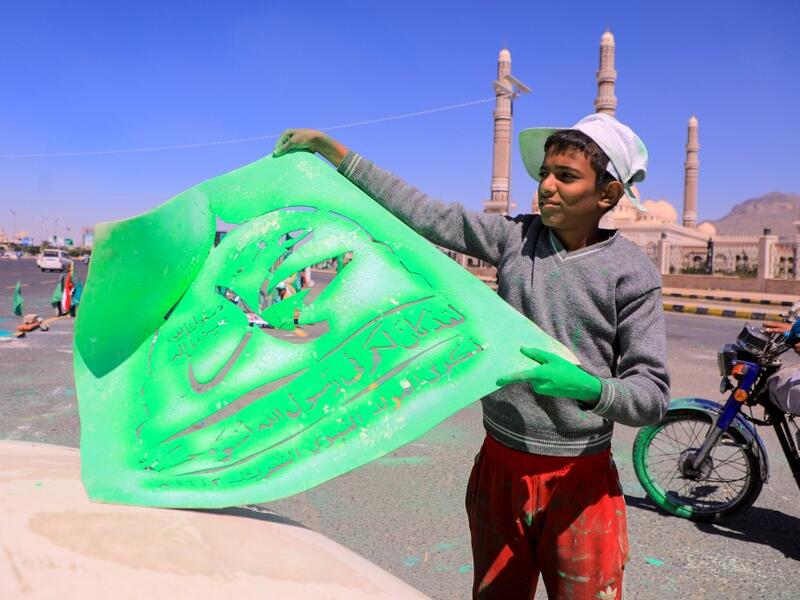 A Yemeni man adjusts a stencil bearing the name of Islam's Prophet Mohammad before spray painting it on a truck in front of Al-Saleh mosque in the capital Sanaa on October 24, 2020, in response to comments by French President Emmanuel Macron defending cartoons of the Prophet Mohammed. MOHAMMED HUWAIS / AFP