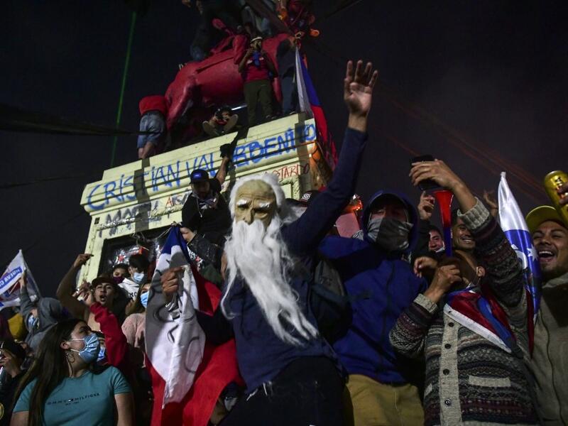 Demonstrators supporting the reform of the Chilean constitution celebrate while waiting for the referendum official results at Plaza Italia square in Santiago on October 25, 2020. Chile's President Sebastian Pinera called on the nation to work together for a "new constitution" after Chileans voted overwhelmingly to replace their dictatorship-era charter.  MARTIN BERNETTI / AFP