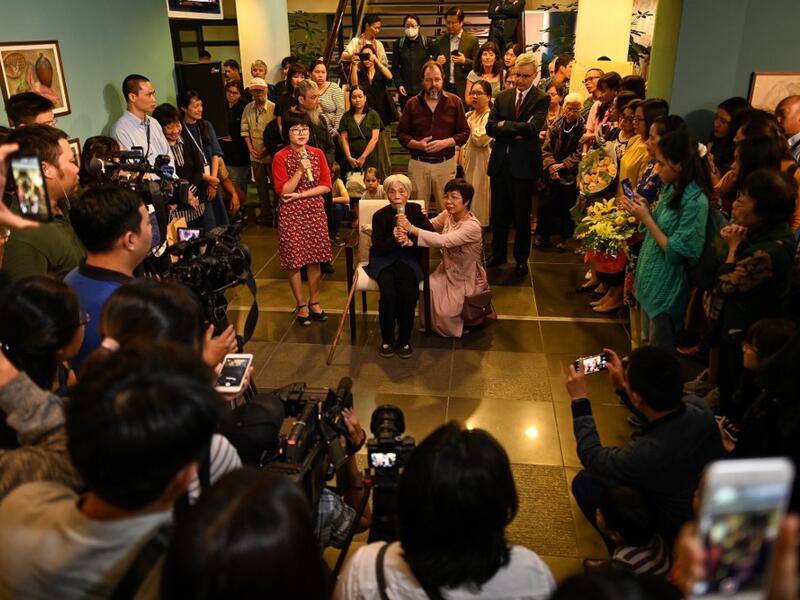 This photograph taken on October 22, 2020 shows 89-year-old Vietnamese artist Mong Bich addressing guests during the opening of her first solo exhibition at the French Cultural Centre in Hanoi. Bich specialises in silk paintings of daily life and ordinary people, women in particular, and ploughed a lonely furrow during many years of war when artists were steered towards the army or frontline workers as subjects. Manan VATSYAYANA / AFP