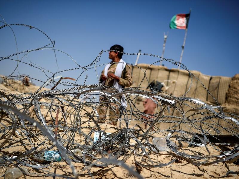 In this photo taken on September 27, 2020, a policeman keeps watch as he stands outside an outpost set up against Taliban fighters at Aziz Abad village in Maiwand district of Kandahar province. The dry and dusty village of Aziz Abad in Maiwand district sits on the frontline of Afghanistan's war and is currently under government control -- but only just. WAKIL KOHSAR / AFP