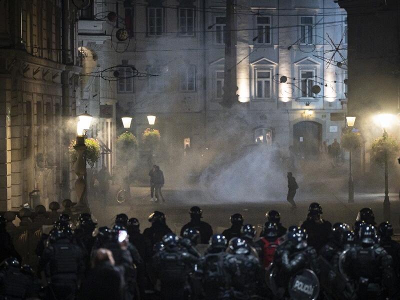 Protesters run through tear gas as they clash with police during the rally against government’s coronavirus restrictions in Ljubljana on November 5, 2020. Jure Makovec / AFP