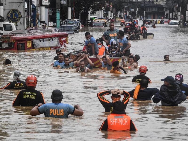 Rescuers pull a rubber boat carrying residents through a flooded street after Typhoon Vamco hit in Marikina City, suburban Manila on November 12, 2020. Ted ALJIBE / AFP