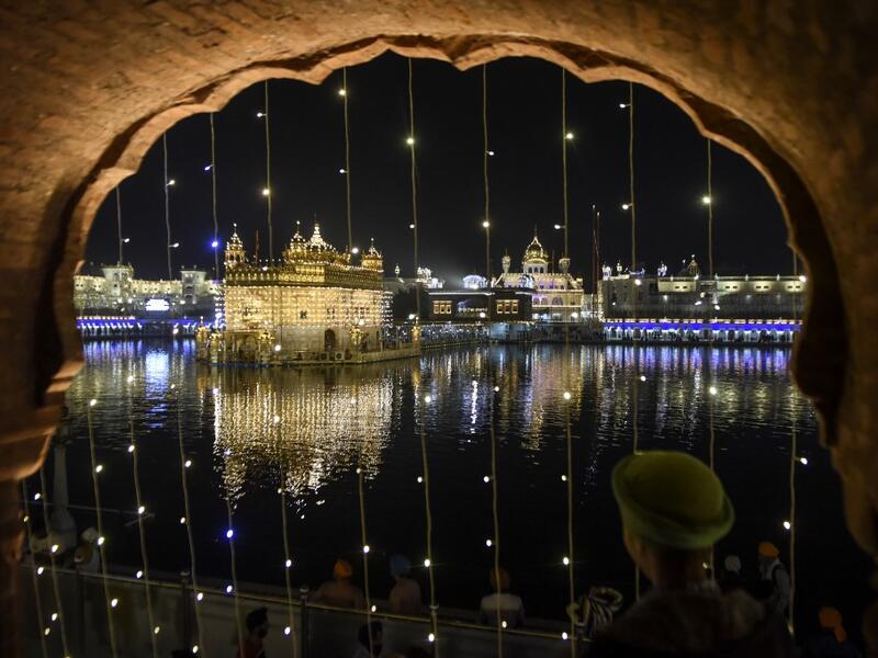 Sikh devotees pay respect on the eve of Bandi Chhor Divas, a Sikh festival coinciding with Diwali, the Hindu festival of light, at the illuminated Golden Temple in Amritsar on November 13, 2020. NARINDER NANU / AFP