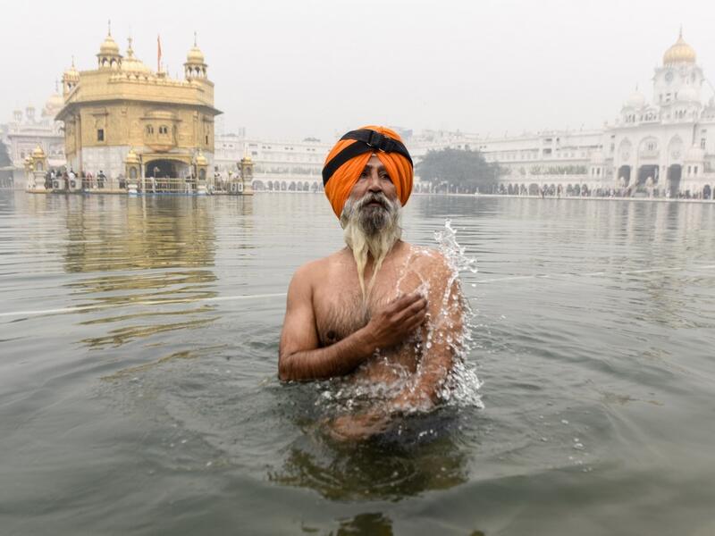 A Sikh devotee takes a dip in the holy sarovar (water tank) on the occasion of Bandi Chhor Divas, a Sikh festival coinciding with Diwali, the Hindu festival of light, at the Golden Temple in Amritsar on November 14, 2020. NARINDER NANU / AFP