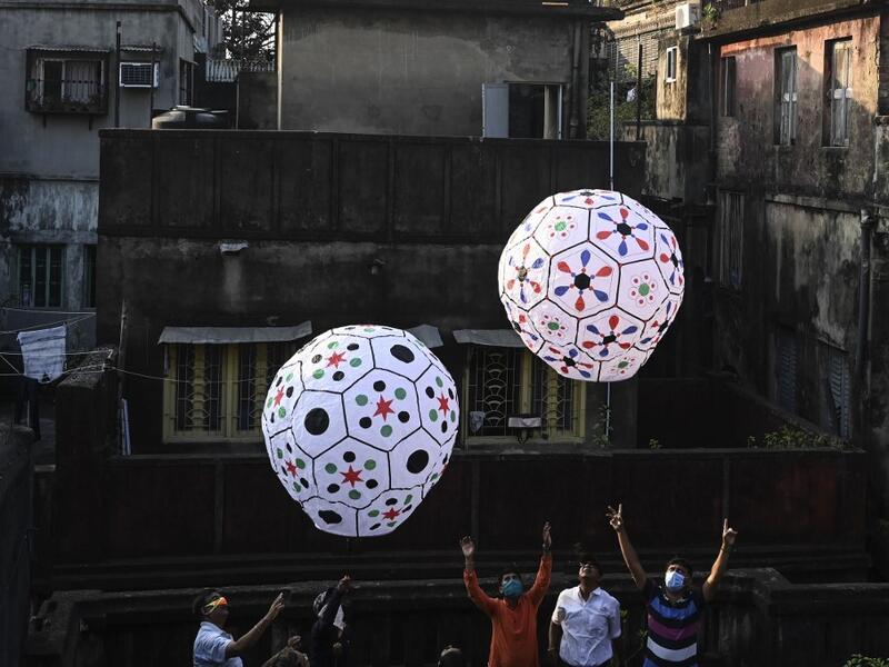 Revellers release handmade sky-lanterns from the terrace of a building to celebrate Diwali, the Hindu festival of lights, in Kolkata on November 14, 2020. Dibyangshu SARKAR / AFP