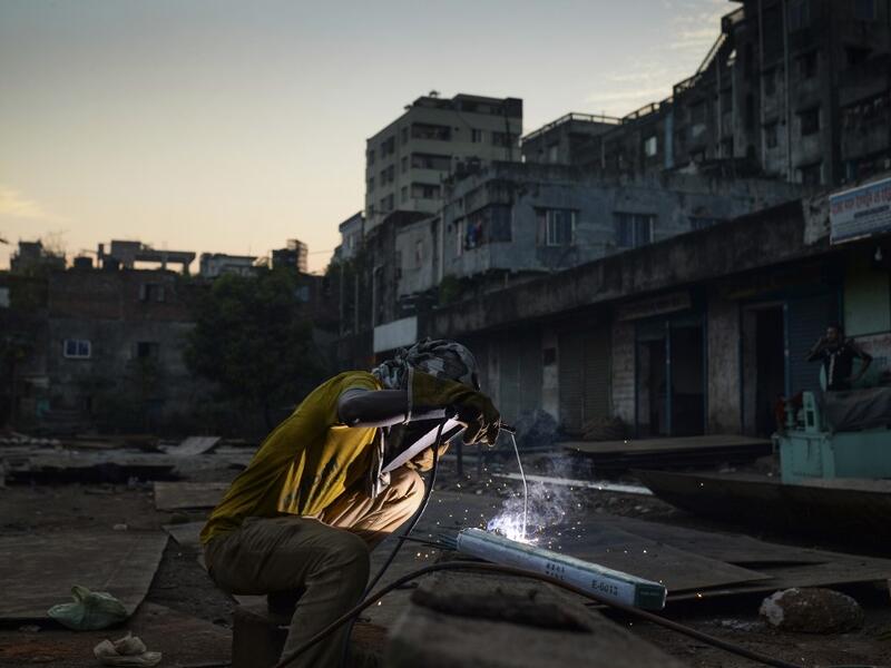 In this picture taken on November 12, 2020 a dockyard worker welds a ship's part on the banks of the Buriganga River in Char Kaliganj on the outskirts of Dhaka. Rivers are the lifeblood of the delta nation of 168 million people where much of the low-lying land is accessed via boat, with Bangladesh's strong economic growth of recent years fuelling more investments in new and bigger ships. Munir UZ ZAMAN / AFP