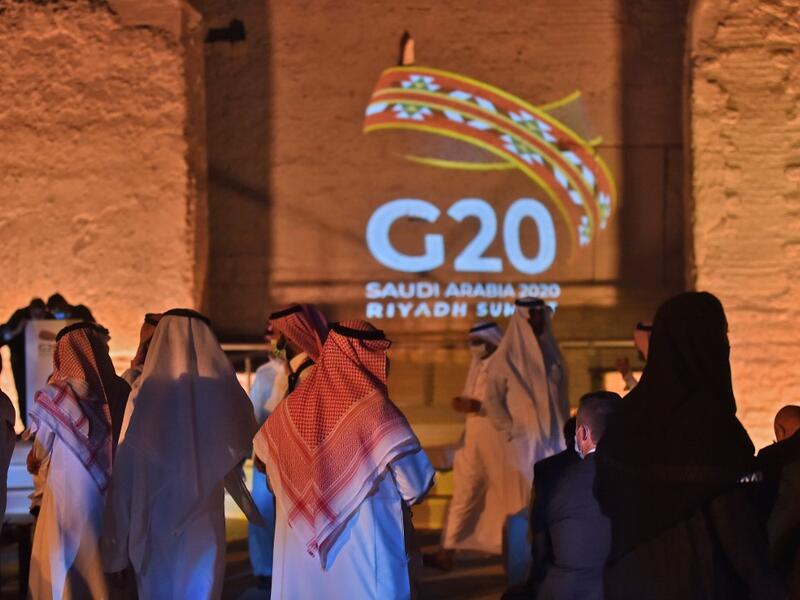 The G20 logo is projected at the historical site of al-Tarif in Diriyah district, on the outskirts of Saudi capital Riyadh, on November 20, 2020. Saudi Arabia hosts the G20 summit on November 21 in a first for an Arab nation, with the downsized virtual forum dominated by efforts to tackle a resurgent coronavirus pandemic and crippling economic crisis. FAYEZ NURELDINE / AFP
