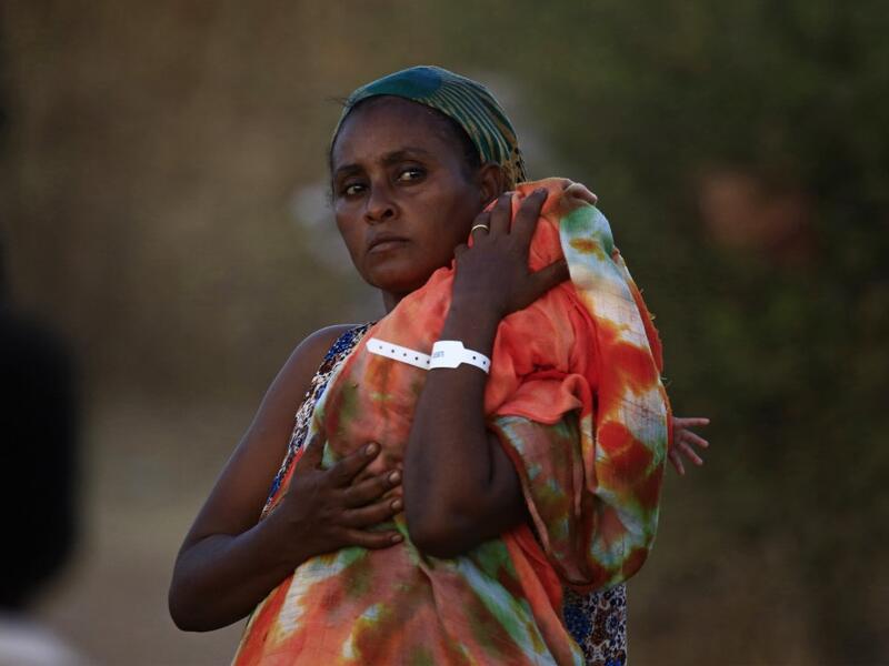 An Ethiopian refugee who fled fighting in Tigray province carries her baby as she walks at the Um Rakuba camp in Sudan's eastern Gedaref province, on November 21, 2020. AFP