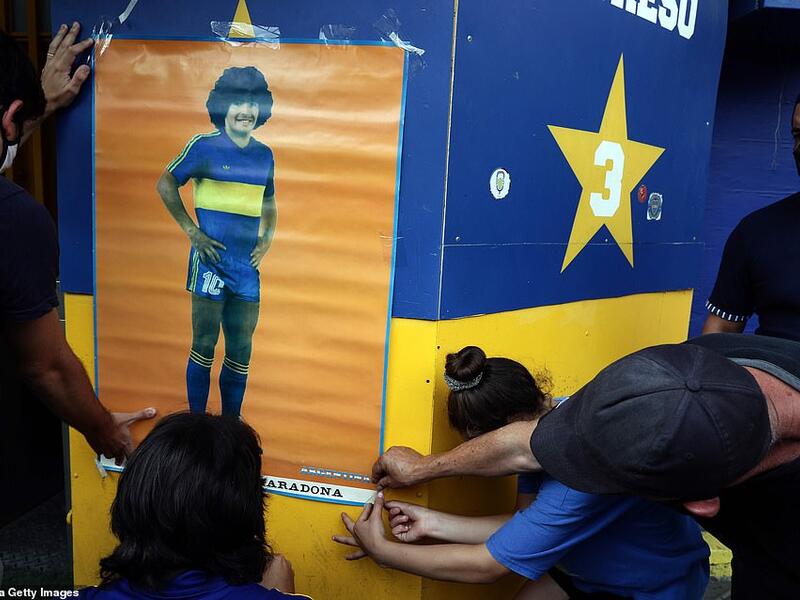 People hang a poster of the late Argentine football star Diego Maradona outside the Argentina's Boca Juniors La Bombonera stadium where people gather to mourn his death in Buenos Aires, on November 25, 2020. (AFP/File)