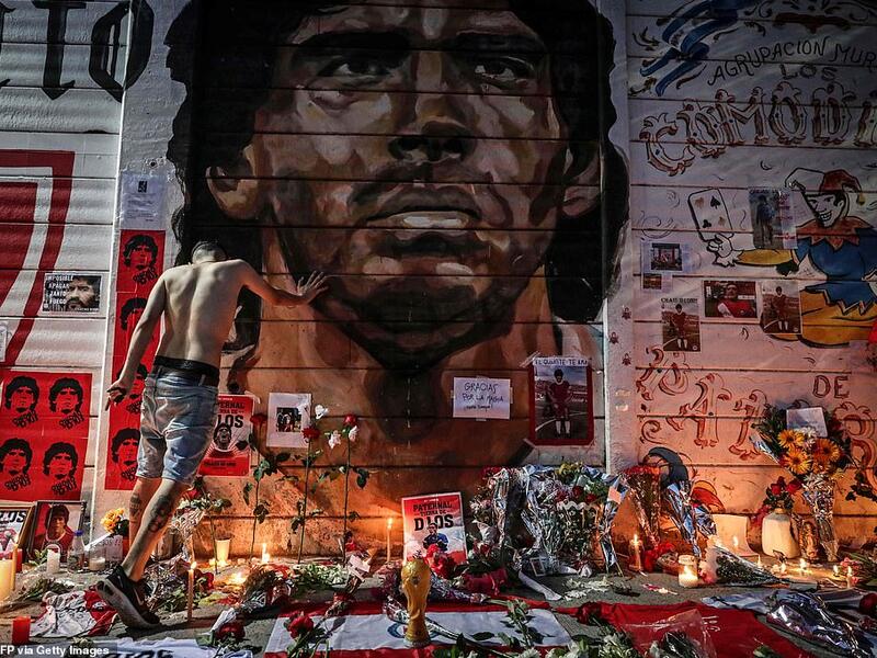 Flowers, posters and other items are left at a makeshift shrine outside the stadium named after Maradona in Buenos Aires. AFP/File