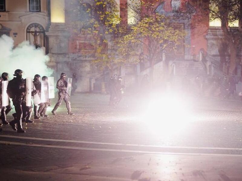 Protesters run through tear gas as they clash with police during the rally against government’s coronavirus restrictions in Ljubljana on November 5, 2020.