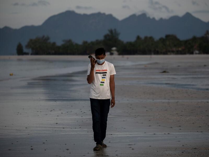 This picture taken on November 16, 2020 shows Rohingya refugee "Abdu Hamid" (using a pseudonym) holding his mobile phone on the Malaysian island of Langkawi, during a video call with his wife who is living at the Kutupalong refugee camp in Ukhia in southern Bangladesh. The video-call app they used to get married in 2017 remains the only means of contact for Julekha and her husband, Abdu Hamid, a Rohingya hotel worker. Mohd RASFAN / AFP