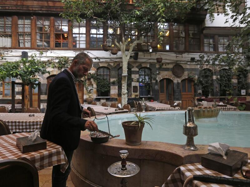 Raed al-Jabri, 61-year-old Syrian, works inside his home-turned-restaurant in the old part of Syria's capital Damascus on November 10, 2020. LOUAI BESHARA / AFP
