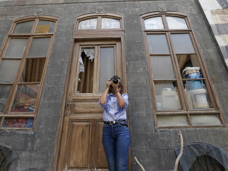 Rania Kataf, 35-year-old Syrian, captures images of the city's famed houses for her digital archive in the old part of Syria's capital Damascus on October 28, 2020. The old city of the Syrian capital is famed for its elegant century-old houses, usually two storeys built around a leafy rectangular courtyard with a carved stone fountain at its centre.LOUAI BESHARA / AFP