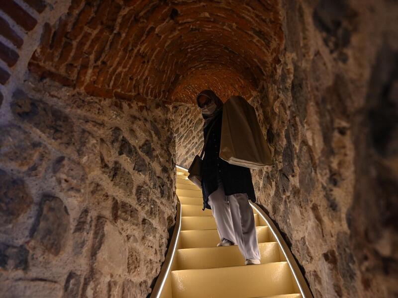 A woman walks upstairs after the restoration of the Galata Tower on October 16, 2020 in Istanbul. The Galata Tower -- an emblematic 14th century monument of Istanbul -- has become the latest victim of such controversy. Ozan KOSE / AFP