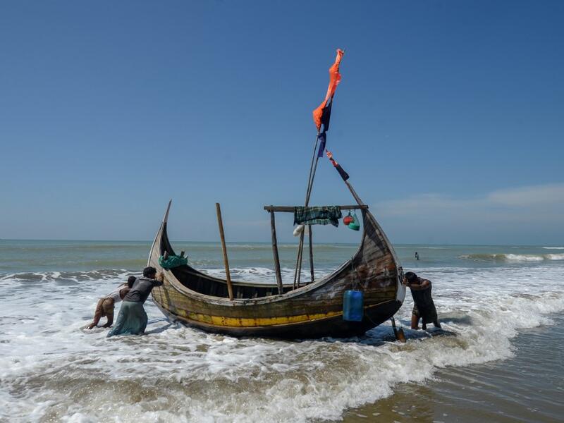 In this photograph taken on October 10, 2020, fishermen set out on a fishing boat at Sabrang beach area, a boarding point of Rohingya refugees migrating to Malaysia by boat. Boatloads of Rohingya landing across Southeast Asia are victims of complex human trafficking networks run by a dizzying web of players, from crime bosses and corrupt cops to poor fishermen, rickshaw drivers and even Rohingya themselves. Munir UZ ZAMAN / AFP