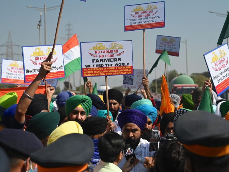 Protesters holding posters argue with policemen while blocking a highway during a nationwide general strike called by farmers to protest against the recent agricultural reforms in Mumbai on December 8, 2020. Indranil MUKHERJEE / AFP