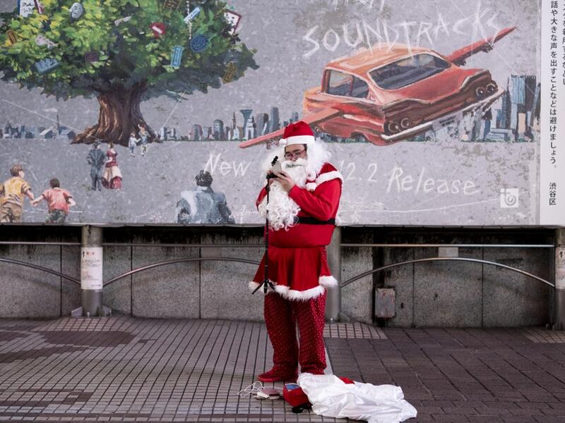 A lone performer dressed as Santa Claus prepares for his performance on Christmas eve, in Shibuya district of Tokyo on December 24, 2020. Philip FONG / AFP