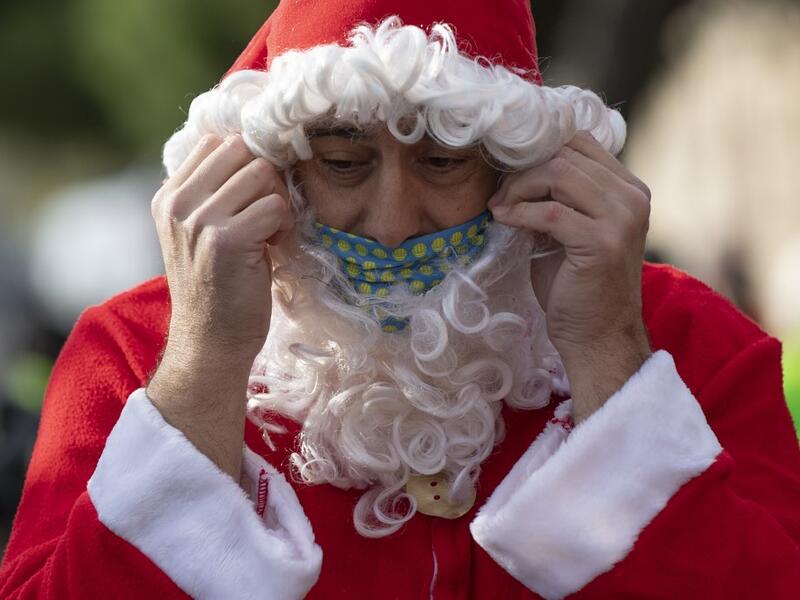 A swimmer in a Santa Claus costume prepares to participate in the 111th edition of the Copa Nadal (Christmas Cup) swimming race in Barcelona's Port Vell on December 25, 2020. The traditional 200-meter Christmas swimming race gathered around 300 participants on Barcelona's Port Vell (old harbour). Josep LAGO / AFP