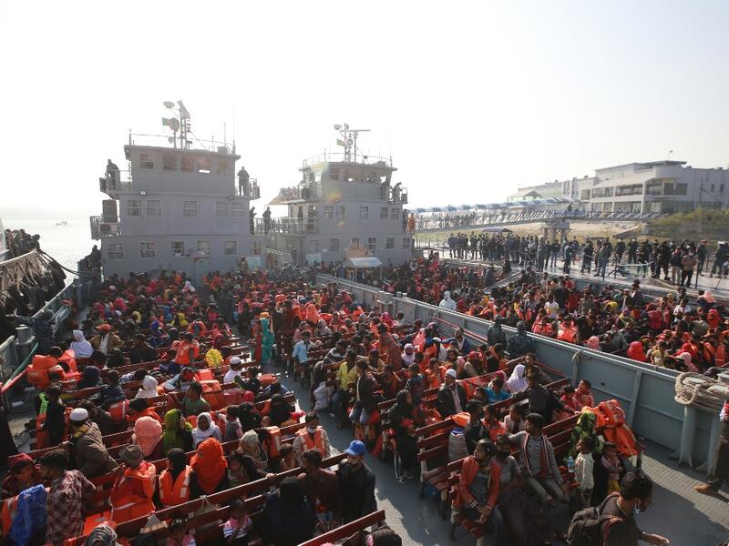 Rohingya refugees sit on a Bangladesh Navy ship as they are relocated to the controversial flood-prone island Bhashan Char in the Bay of Bengal, in Chittagong on December 29, 2020. Rehman ASAD / AFP