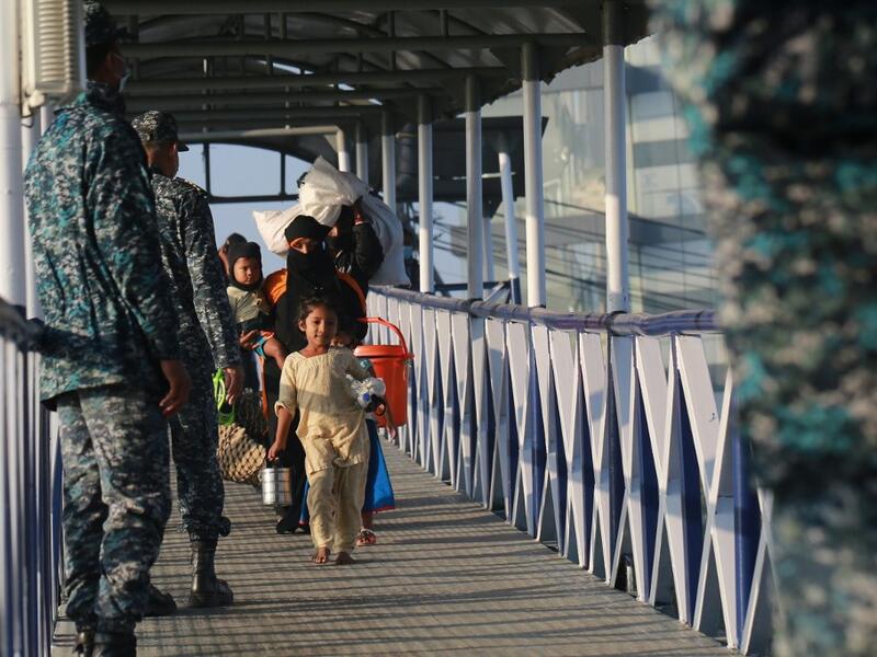 Rohingya refugees embark on a Bangladesh Navy ship as they are relocated to the controversial flood-prone island Bhashan Char in the Bay of Bengal, in Chittagong on December 29, 2020. Rehman ASAD / AFP