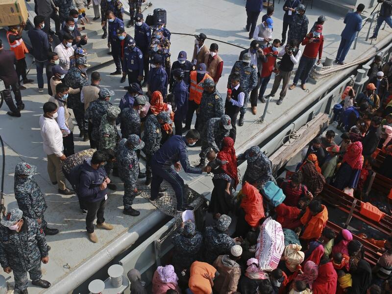 Rohingya refugees disembark from a Bangladesh Navy ship as they are relocated to the controversial flood-prone island Bhashan Char in the Bay of Bengal, in Chittagong on December 29, 2020. REHMAN ASAD / AFP