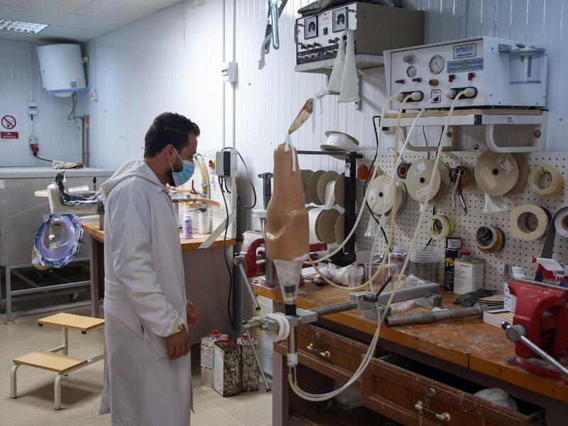 A member of staff works at the National Center for Artificial Limbs, in Libya's port city of Misrata, on December 17, 2020. With Libya's health sector left in tatters by its multiple conflicts since the 2011 revolution, war-wounded Libyans are often sent abroad for treatment, at the expense of the state. However, A national centre for prostheses, being established in Misrata, already has a patient waiting list of more than 3,000 amputees