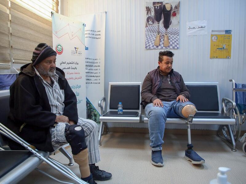 Patients wait for a consultation at the National Center for Artificial Limbs, in Libya's port city of Misrata, on December 17, 2020. With Libya's health sector left in tatters by its multiple conflicts since the 2011 revolution, war-wounded Libyans are often sent abroad for treatment, at the expense of the state. However, A national centre for prostheses, being established in Misrata, already has a patient waiting list of more than 3,000 amputees