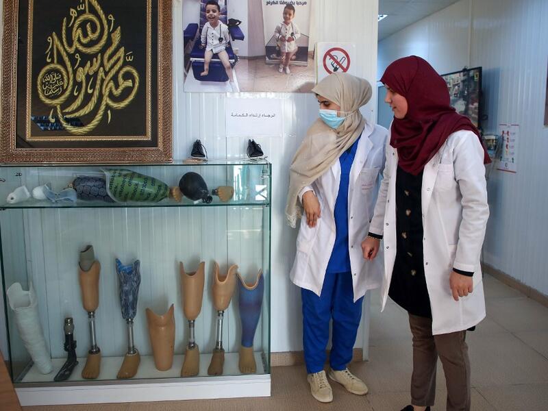 Members of staff work at the National Center for Artificial Limbs, in Libya's port city of Misrata, on December 17, 2020. With Libya's health sector left in tatters by its multiple conflicts since the 2011 revolution, war-wounded Libyans are often sent abroad for treatment, at the expense of the state. However, A national centre for prostheses, being established in Misrata, already has a patient waiting list of more than 3,000 amputees