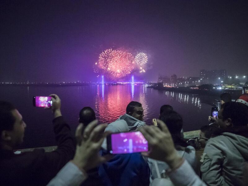 People watch fireworks explode over the River Nile in the Egyptian capital Cairo during New Year's Eve celebrations on December 31, 2020. Khaled DESOUKI / AFP