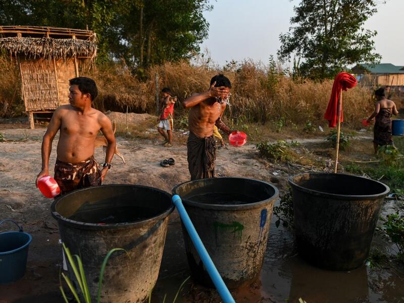 This photo taken on January 11, 2021 shows Chin ethnic people washing in Bethel village in Hmawbi, on the outskirts of Yangon, where hundreds of members of the Chin ethnic community have settled after being displaced by fighting between Myanmar's military and the Arakan Army in the country's north.  Ye Aung THU / AFP