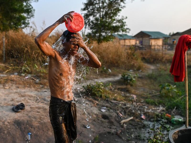This photo taken on January 11, 2021 shows a Chin man washing in Bethel village in Hmawbi, on the outskirts of Yangon, where hundreds of members of the Chin ethnic community have settled after being displaced by fighting between Myanmar's military and the Arakan Army in the country's north.  Ye Aung THU / AFP