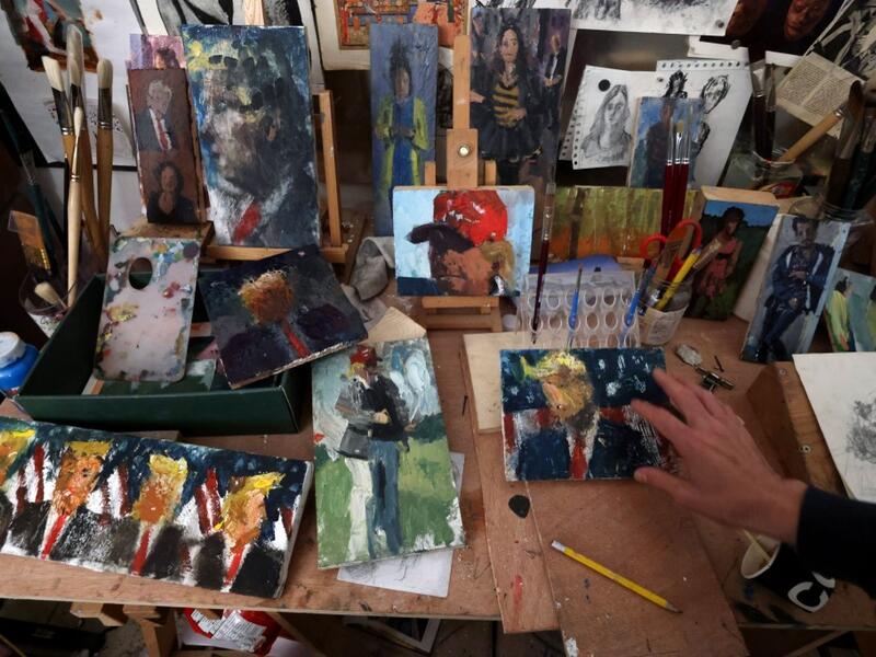 Israeli painter Iddo Markus arranges his paintings of former US president Donald Trump, at his studio in the northern port city of Haifa, on January 22, 2021. Markus became fascinated by the "tragic figure" of Donald Trump, and the walls and floor of his studio are packed with some 120 portraits of the former US presidents. Emmanuel DUNAND / AFP