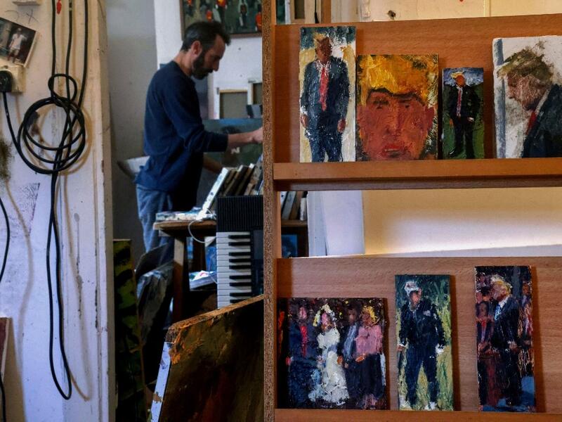 Israeli painter Iddo Markus works at his studio where he displays some of his paintings of former US president Donald Trump, in the northern port city of Haifa, on January 22, 2021. Markus became fascinated by the "tragic figure" of Donald Trump, and the walls and floor of his studio are packed with some 120 portraits of the former US presidents. Emmanuel DUNAND / AFP
