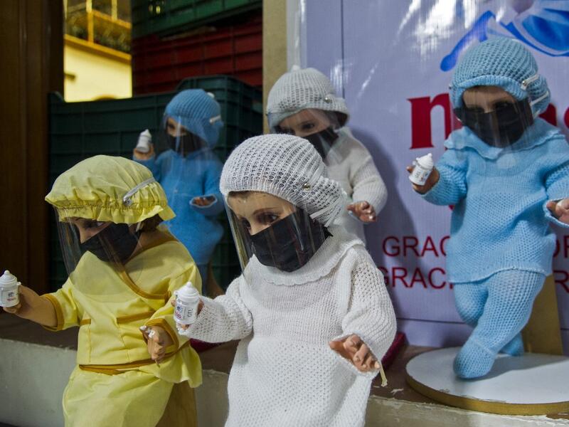 View of dolls displayed for sale at the ¨Nino Uribe¨ traditional Mexican store in Mexico City on January 27, 2021. ¨Nino Uribe¨ sells representations of the Baby Jesus called Baby COVID to raise awareness on the preventive measures to take amid the COVID-19 coronavirus pandemic. CLAUDIO CRUZ / AFP