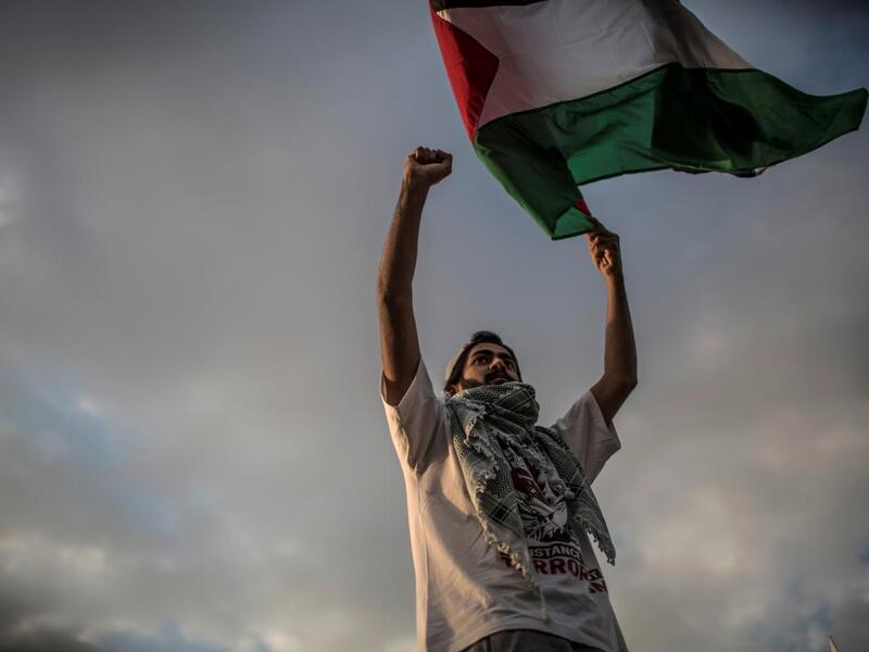 A man waves a Palestinian flag during a protest to mark Nakba Day (AFP)
