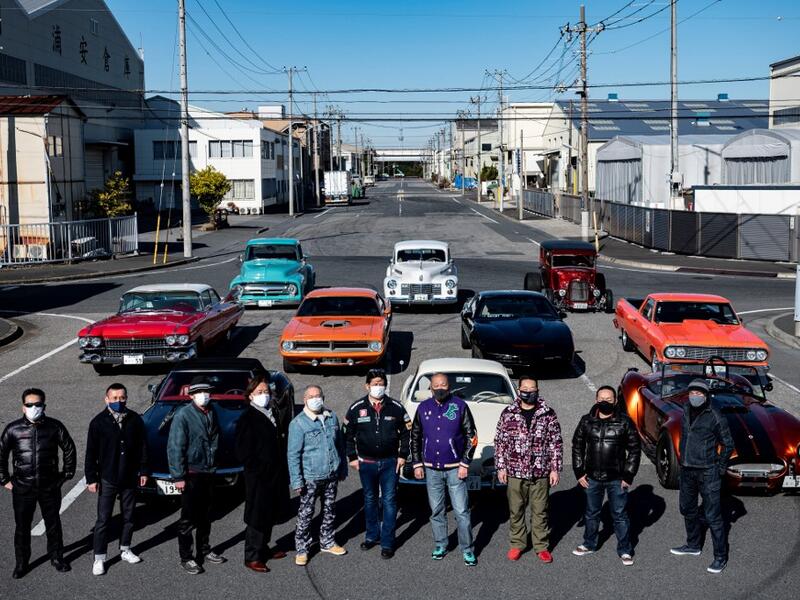 This picture taken on January 31, 2021 shows car owners posing for a photo during a gathering of auto enthusiasts in Urayasu, an eastern suburb of Tokyo. A loose club of fans rolls up most weekends in central Tokyo to show off their Cadillacs, Chevrolets and other modern classic vehicles from the mid to late 20th century. Philip FONG / AFP