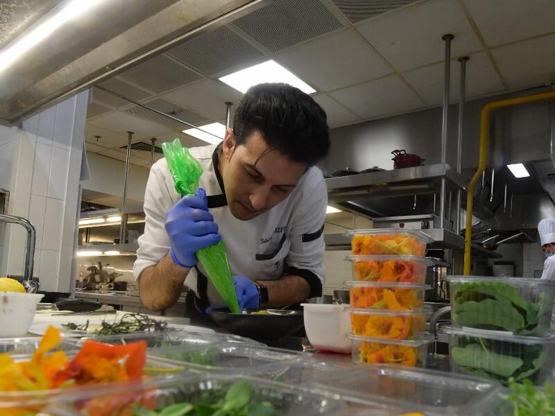 Tunisian chef Bassem Bizid uses edible flowers to prepare his dishes at a luxury hotel in Gammarth, an upscale northern suburb of the capital Tunis, on February 5, 2021. Tunisians already use certain flowers in their traditional cuisine. Some sweets feature dried rose petals, while lavender is an ingredient in a spice mix used in couscous recipes. But fresh flowers, which can be used for dishes from soups to salads as well as teas, are a novelty.  FETHI BELAID / AFP