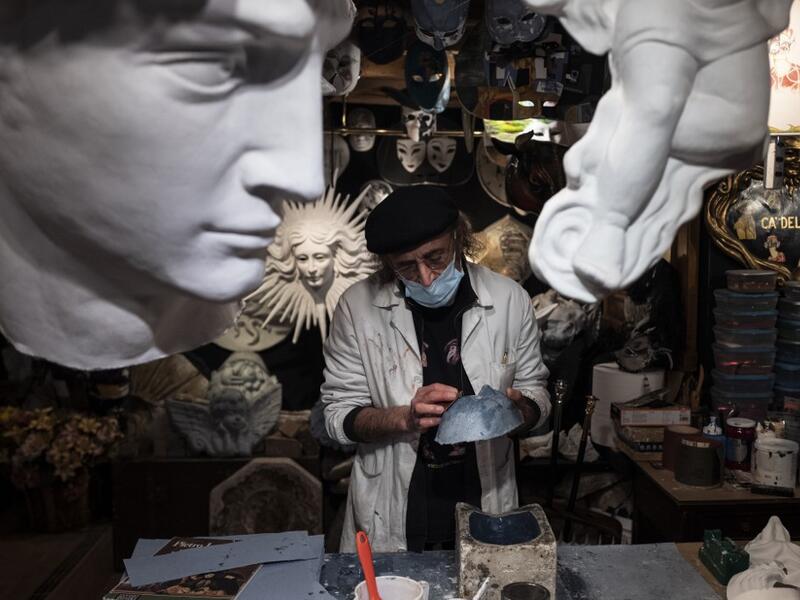 Mask artisan Hamid Seddighi works on a papier-mache mask in his laboratory 'Ca del Sol' in Venice on February 6, 2021, as the traditional Venice carnival is being cancelled due to the Covid-19 pandemic. Marco Bertorello / AFP