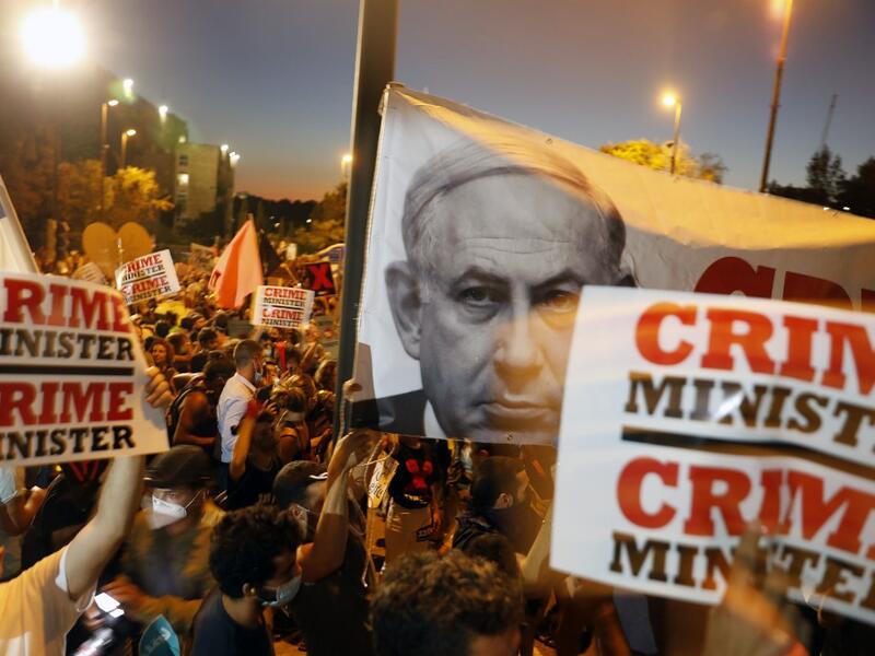 In this file photo taken on July 21, 2020, Israelis protest against Israeli Prime Minister Benjamin Netanyahu in Jerusalem. Israel's Prime Minister Benjamin Netanyahu returns to court on February 8, 2021 to formally respond to the corruption charges filed against him, as his trial enters an intensified phase six weeks before he faces re-election. MENAHEM KAHANA / AFP