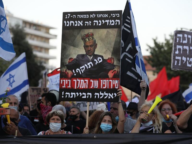  In this file photo taken on July 21, 2020, Israelis protest against Israeli Prime Minister Benjamin Netanyahu in Jerusalem. Israel's Prime Minister Benjamin Netanyahu returns to court on February 8, 2021 to formally respond to the corruption charges filed against him, as his trial enters an intensified phase six weeks before he faces re-election. Menahem KAHANA / AFP