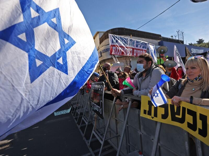 Israelis demonstrate outside the court as Prime Minister Benjamin Netanyahu's corruption trial resumes in occupied east Jerusalem, on February 8, 2021. Israel's Prime Minister Benjamin Netanyahu returns to court to formally respond to the corruption charges against him, as his trial enters an intensified phase six weeks before he faces re-election. EMMANUEL DUNAND / AFP