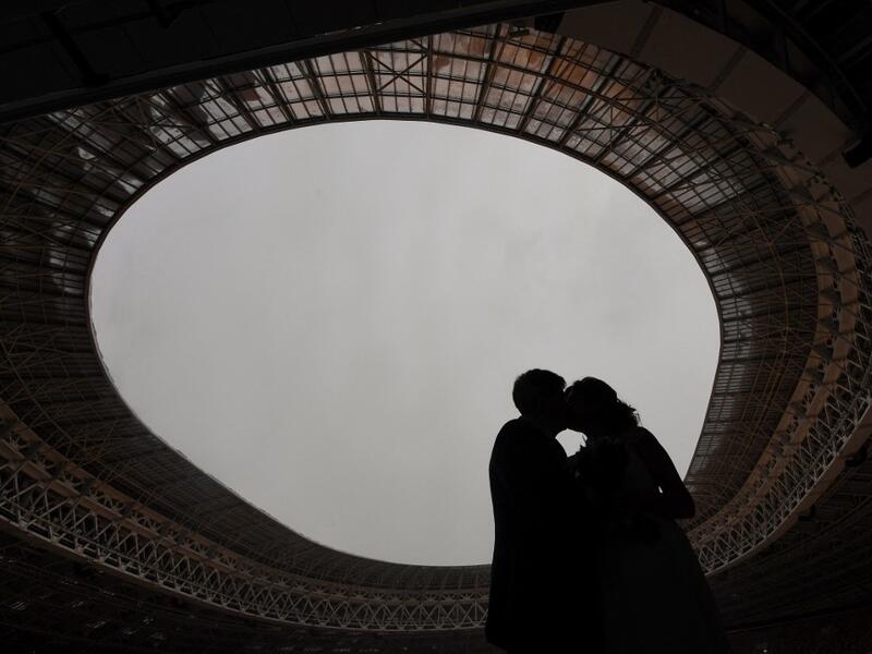 Newlyweds kiss during their wedding ceremony at the Luzhniki stadium in Moscow on February 12, 2021, days before Valentine's Day. NATALIA KOLESNIKOVA / AFP
